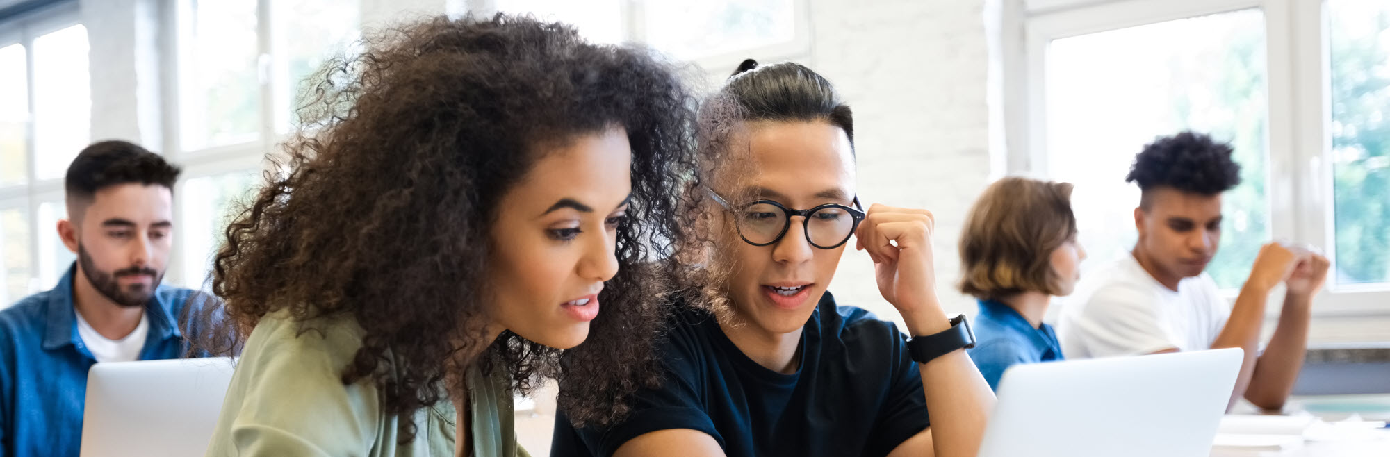 A man and a woman looking learning together online